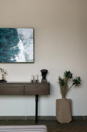 a living room with a table and a picture on the wall at Casa De Roopa by Stay ALYF, Mandrem in Mandrem