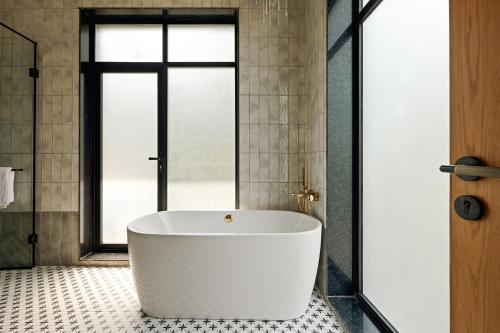a white bath tub in a bathroom with a window at Casa De Roopa by Stay ALYF, Mandrem in Mandrem