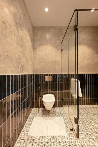 a bathroom with a toilet and a glass shower at Casa De Roopa by Stay ALYF, Mandrem in Mandrem