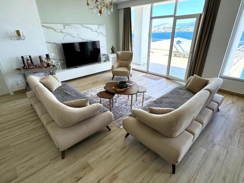 Una sala de estar con un sofá y dos sillas y una mesa. en Seafront Oasis Luxury Apartment, with Sae View, en Sarandë