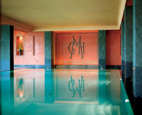 ヴェルバーニアにあるグランド ホテル マジェスティックの赤い壁の客室の水のプール