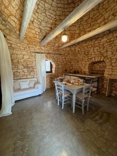 a room with a table and chairs in a stone building at Masseria Colombo in Mottola