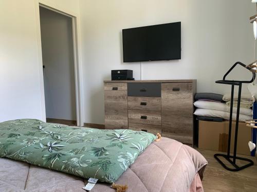 - une chambre avec une commode et une télévision murale à écran plat dans l'établissement Maison au calme avec piscine chauffée à 10 mn des plages, à Seignosse