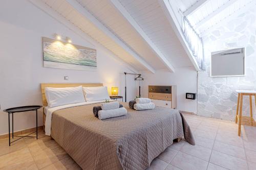 a bedroom with a bed with two towels on it at Oceanis Rooms Apartments in Barbati