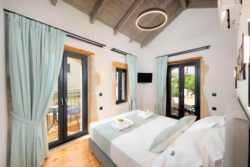 a bedroom with a bed and a large window at Roustico Luxury Villa Heated Whirpool in Rethymno Town