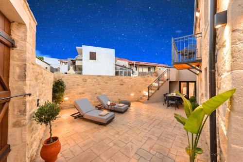 a patio with two lounge chairs and a table at Roustico Luxury Villa Heated Whirpool in Rethymno Town