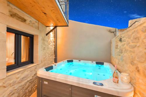 a jacuzzi tub in a room with a window at Roustico Luxury Villa Heated Whirpool in Rethymno Town