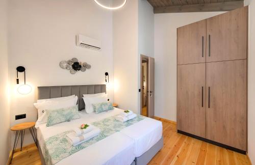 a bedroom with a large white bed and a wooden cabinet at Roustico Luxury Villa Heated Whirpool in Rethymno Town