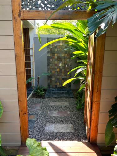 an entrance to a garden with a wooden door at La Villa Paille en Queue in Saint-Gilles les Bains