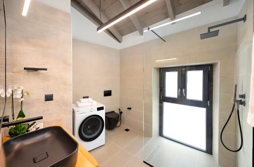 a bathroom with a washing machine and a window at Roustico Luxury Villa Heated Whirpool in Rethymno Town