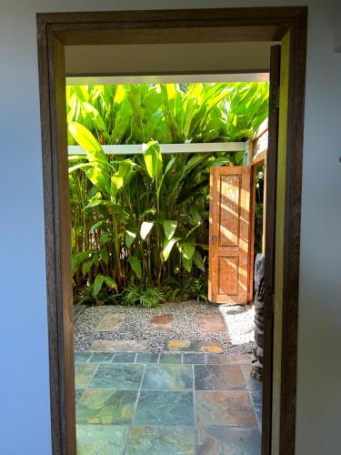 an open door to a garden with plants at La Villa Paille en Queue in Saint-Gilles les Bains