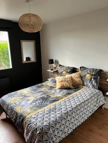una camera da letto con un letto con un piumone di Limoges à la Plage proche de tout avec parking a Limoges