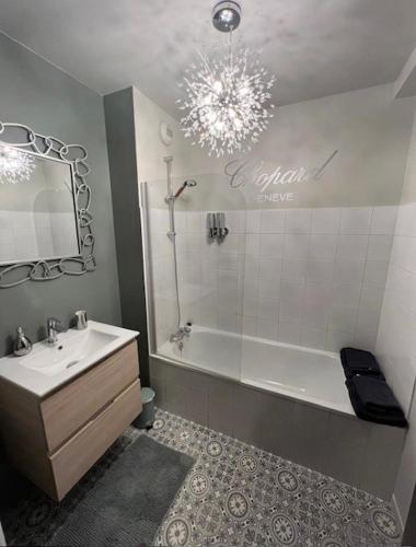 une salle de bain avec une baignoire, un lavabo et un miroir dans l'établissement Limoges à la Plage proche de tout avec parking, à Limoges