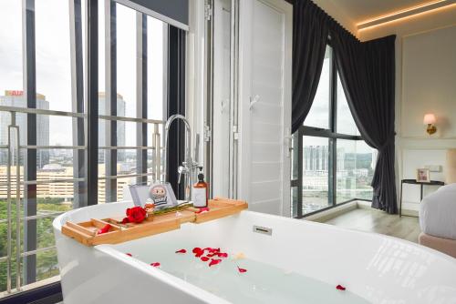 a bath tub in a room with large windows at Midvalley Southkey Mosaic Suite by Nest Home in Johor Bahru
