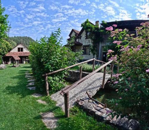 a house with a stone bridge in front of a yard at Eco Garden Dilijan in Dilijan