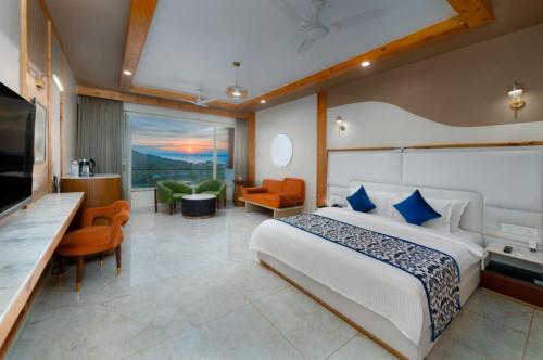 a hotel room with a bed and a television at Grand Continent Morjim in Morjim