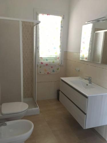 a bathroom with a sink and a toilet and a window at Everything a bike ride away! 10 mins to the beach with free parking! in Marina di Grosseto