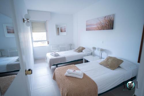 a white room with two beds and a window at Minerva NeW in Benalmádena