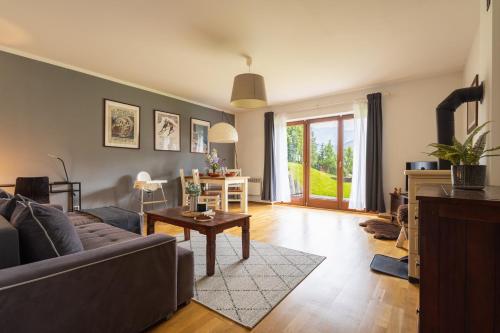a living room with a couch and a table at Apartament Południowy z widokiem- sauna, jacuzzi, kominek in Kościelisko