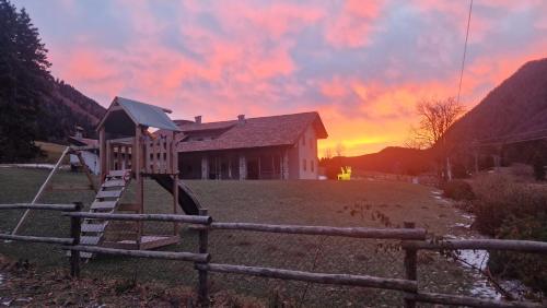 a playground in front of a house with a sunset at B&B La Paganina in Borno