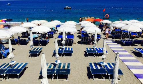 a bunch of chairs and umbrellas on a beach at Villa Chiara Taormina in Taormina