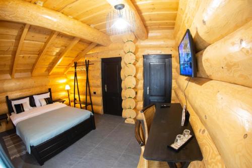 a bedroom with a bed and a television in a cabin at Bucovina Exclusiv in Vama