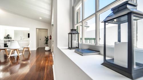a living room with white walls and windows at CASA de FORO - Apartamentos Turísticos in Angra do Heroísmo