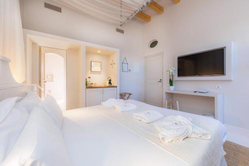 a white bedroom with a bed with towels on it at Yartan Boutique Hotel - Adults Only in Artá