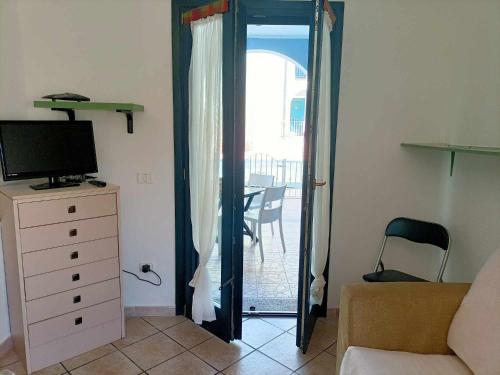 d'un salon avec une porte s'ouvrant sur un balcon. dans l'établissement La Muddizza appartement avec piscine, à Valledoria