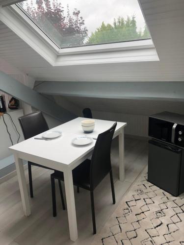 une salle à manger avec une table blanche et une fenêtre dans l'établissement Chez Blandine - jolie chambre et mezzanine climatisées proche UTT infrastructures sportives, à Rosières-près-Troyes