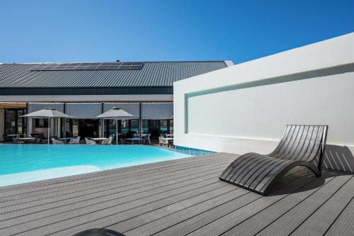SummerstrandにあるBella Breeze Two Bedroom Apartmentのスイミングプールの横のデッキに座る椅子