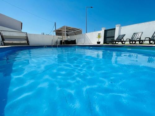 a large blue swimming pool with chairs on a building at Soares Village II in Amoreira