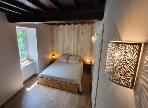 a small bedroom with a bed and a window at Chambres d'hôtes Les Marmottes in Arbéost