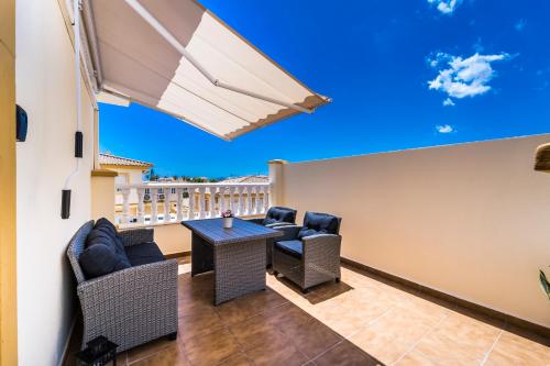 un balcon avec une table, des chaises et un parasol dans l'établissement Exclusive Penthouse - Big Balcony & Private Garden, à Orihuela