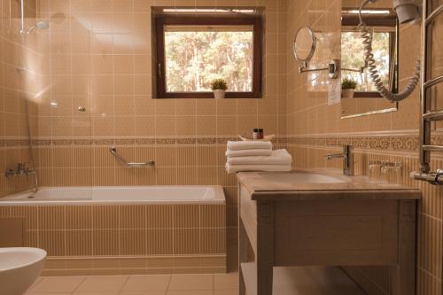 a bathroom with a tub and a sink and a toilet at Pušynė in Birštonas