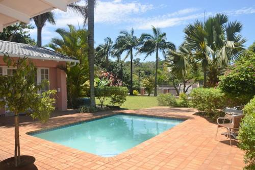 バリートにあるLuxurious Room in excellent proximity to Beachのヤシの木が茂る家の前のスイミングプール