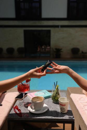 a person holding a cell phone in front of a pool at Elexus Predeal in Predeal