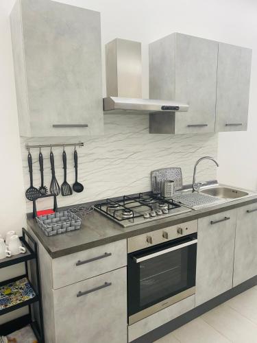 a kitchen with a stove and a sink at Sicilian Rooms in Avola