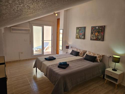 a bedroom with a large bed and a window at Los Belones, Mar Menor España in Los Belones
