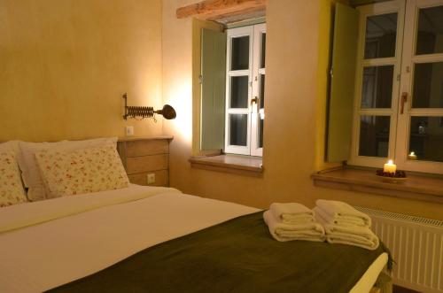 a bedroom with a bed with two windows and towels at Papaevangelou Hotel in Papigko
