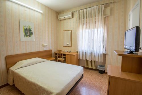 a hotel room with a bed and a television at Albergo Ristorante Edo in Forlimpopoli