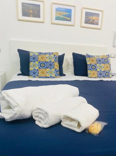 a bed with a pile of towels on it at Sicilian Rooms in Avola