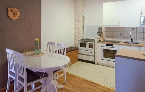 a kitchen with a white table and chairs in it at Holiday Home Podgorska V in Senj