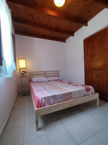 Un dormitorio con una cama y un techo de madera. en Lena Summer Sea Family Vacation House & Yard Chalkidiki, en Sozopoli