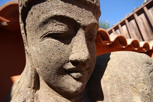 a statue of a head on a rock at Villa Jardín de Buda in Arona