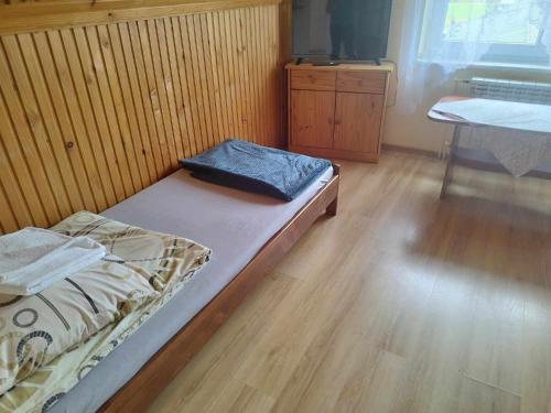 a bed in a room with a wooden floor at DG EWA w Polańczyku in Polańczyk