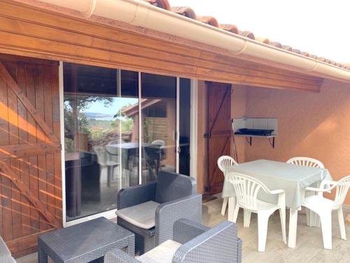 a patio with a white table and chairs and a table at Les lauriers fleurs in Lecci