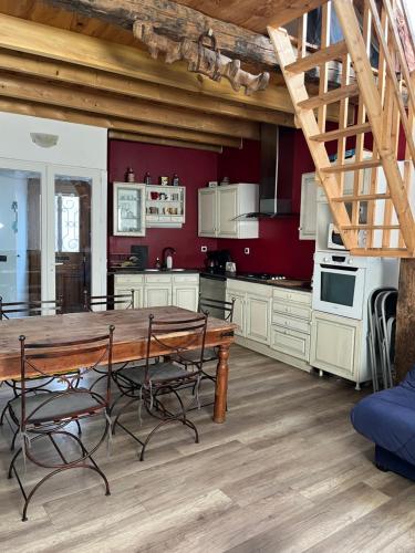 une grande cuisine avec une table et des chaises en bois dans l'établissement location de montagne, à Aste-Béon