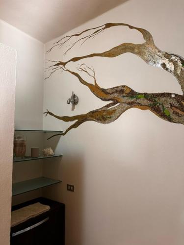a tree mural on the wall of a bathroom at Casa Vacanza Indipendente Cascina Cremasca with pool in Crema