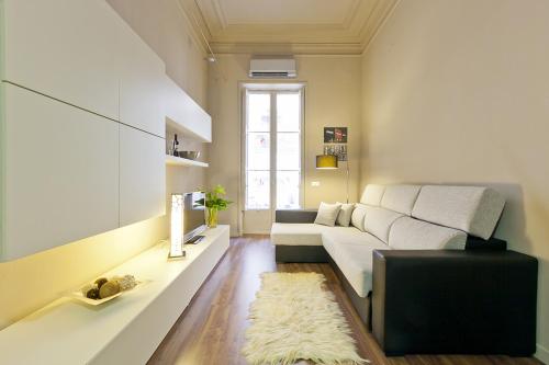 a living room with a white couch and a window at Eixample patio views with amazing terrace in Barcelona
